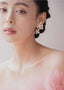 Double flower and pearl gold stud earring on model side view
