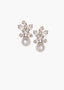 Pair of pearl stud earrings topped with swarovski crystal embellishments on a white background
