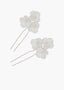 Set of three white floral hairpins with pearls on a white background