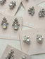 Silver and pearl earrings on 'elizabeth faver' branded cards.