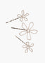Three decorative hair pins with floral designs on a white background