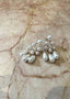Pearl chandelier earrings laid out on a piece of blush marble