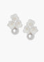 Pair of earrings with white floral designs and pearl-like centers on a white background